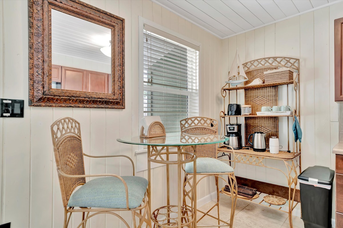 Sip your morning coffee at this charming bistro table, where wicker details and coastal light create a warm, inviting spot just for you.