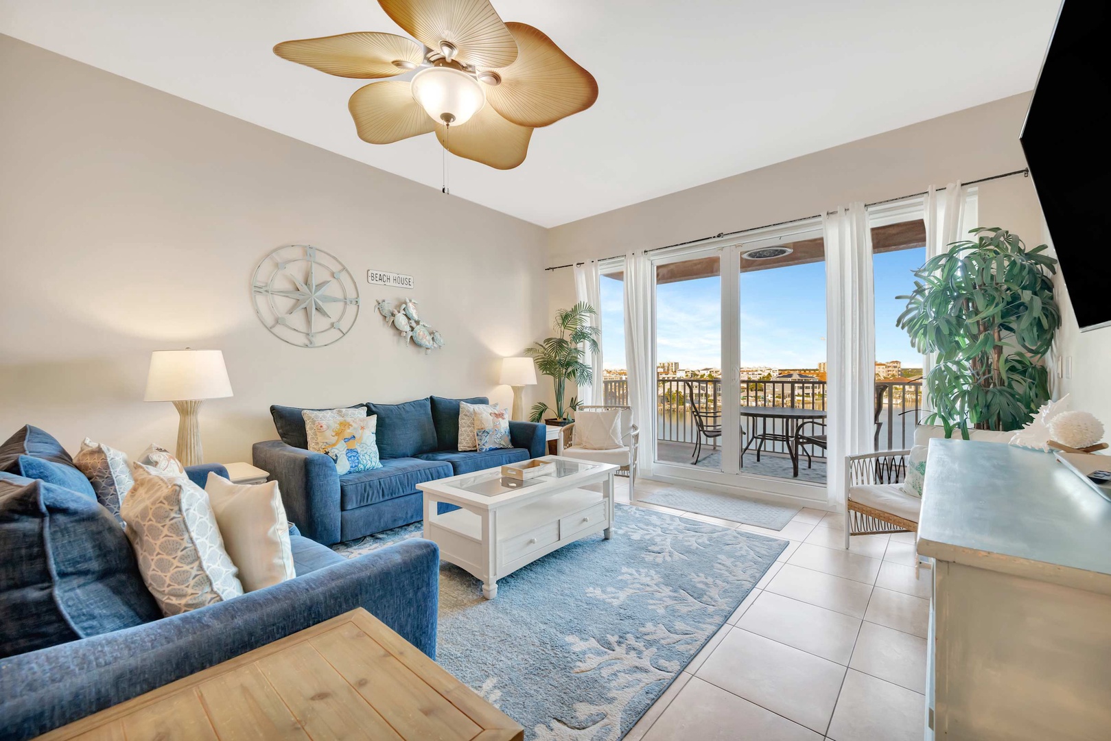 Sink into plush sofas and let the gentle breeze from your balcony drift through. Coastal-themed touches add warmth, while French doors frame your serene outdoor space.