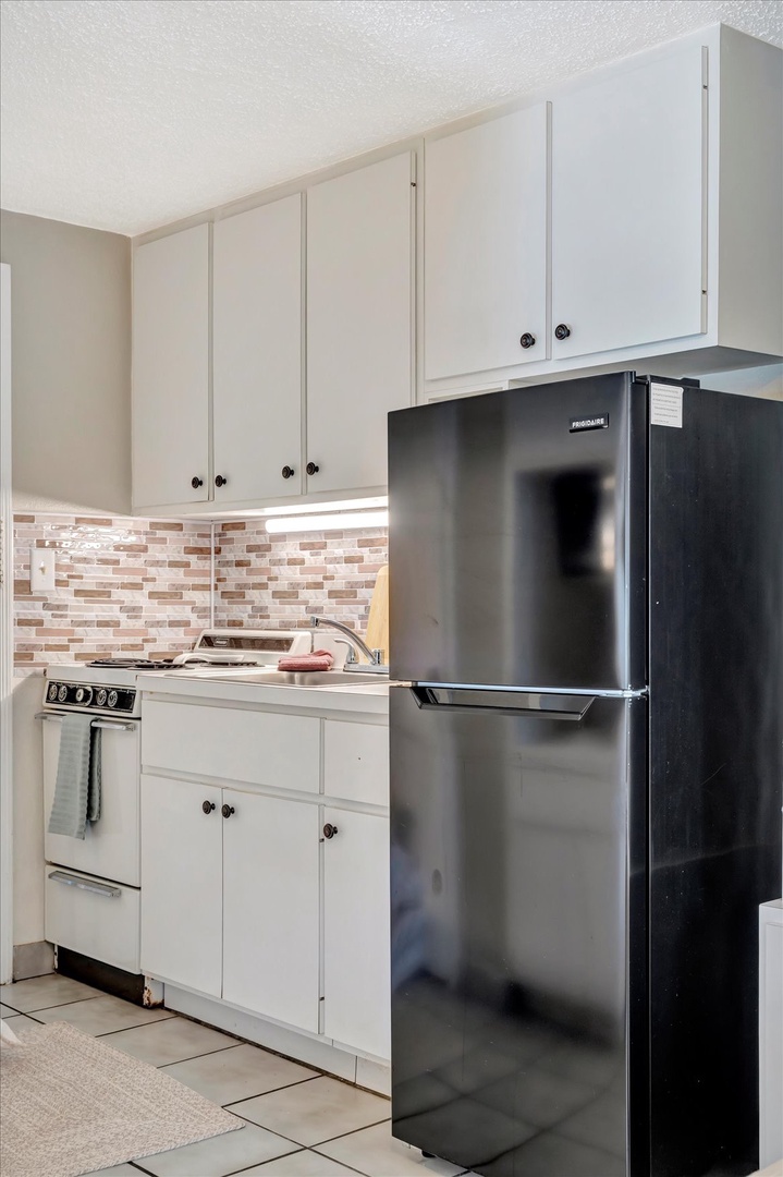 Your fully equipped kitchen awaits with stainless steel appliances, modern tiled backsplash, and ample cabinet space—perfect for preparing your favorite meals during your stay.