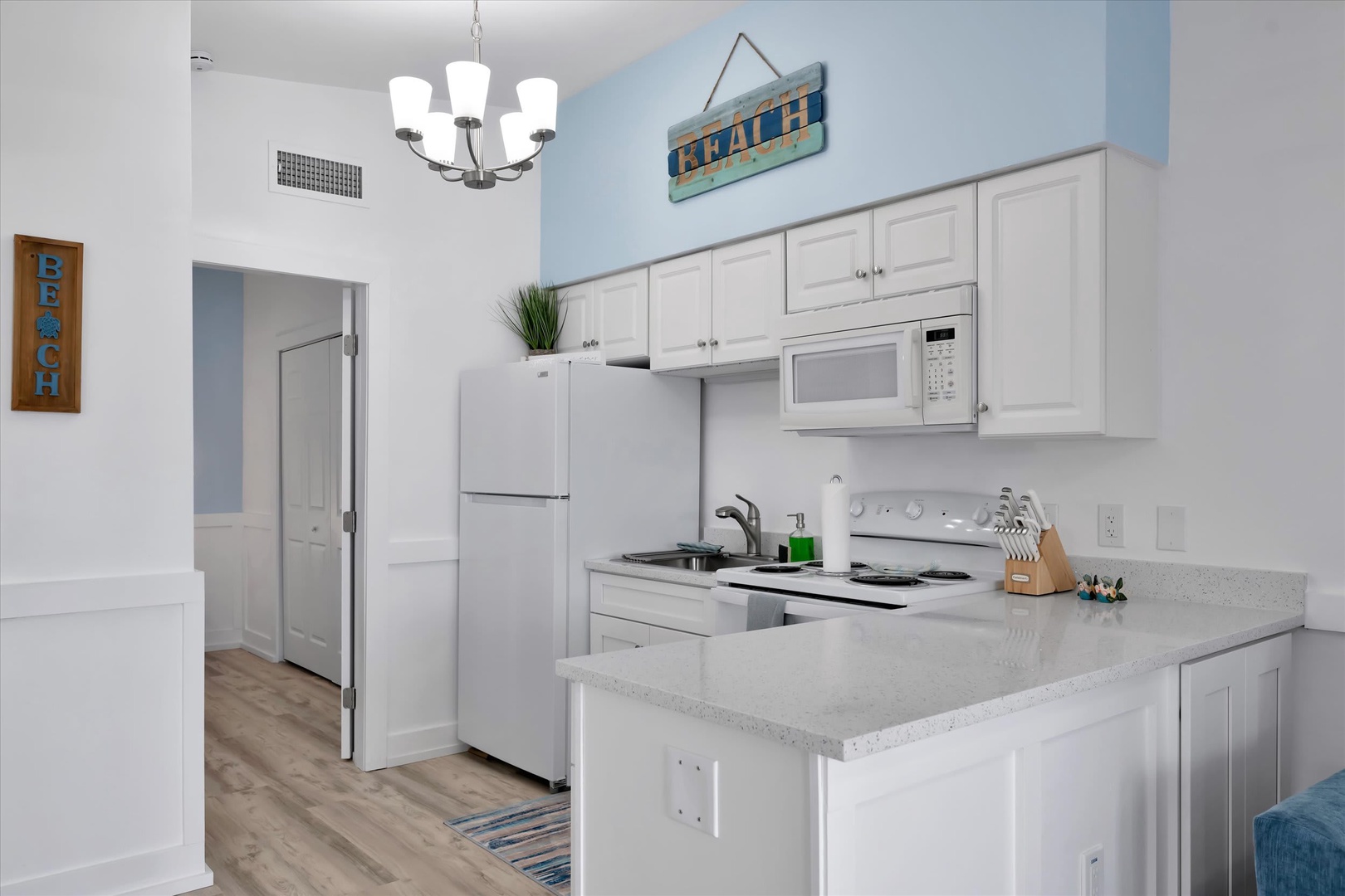 Your bright, fully-equipped kitchen invites you to prepare meals with ease, featuring modern appliances, generous counter space, and cheerful beach-themed touches that set the tone for a relaxing coastal getaway.