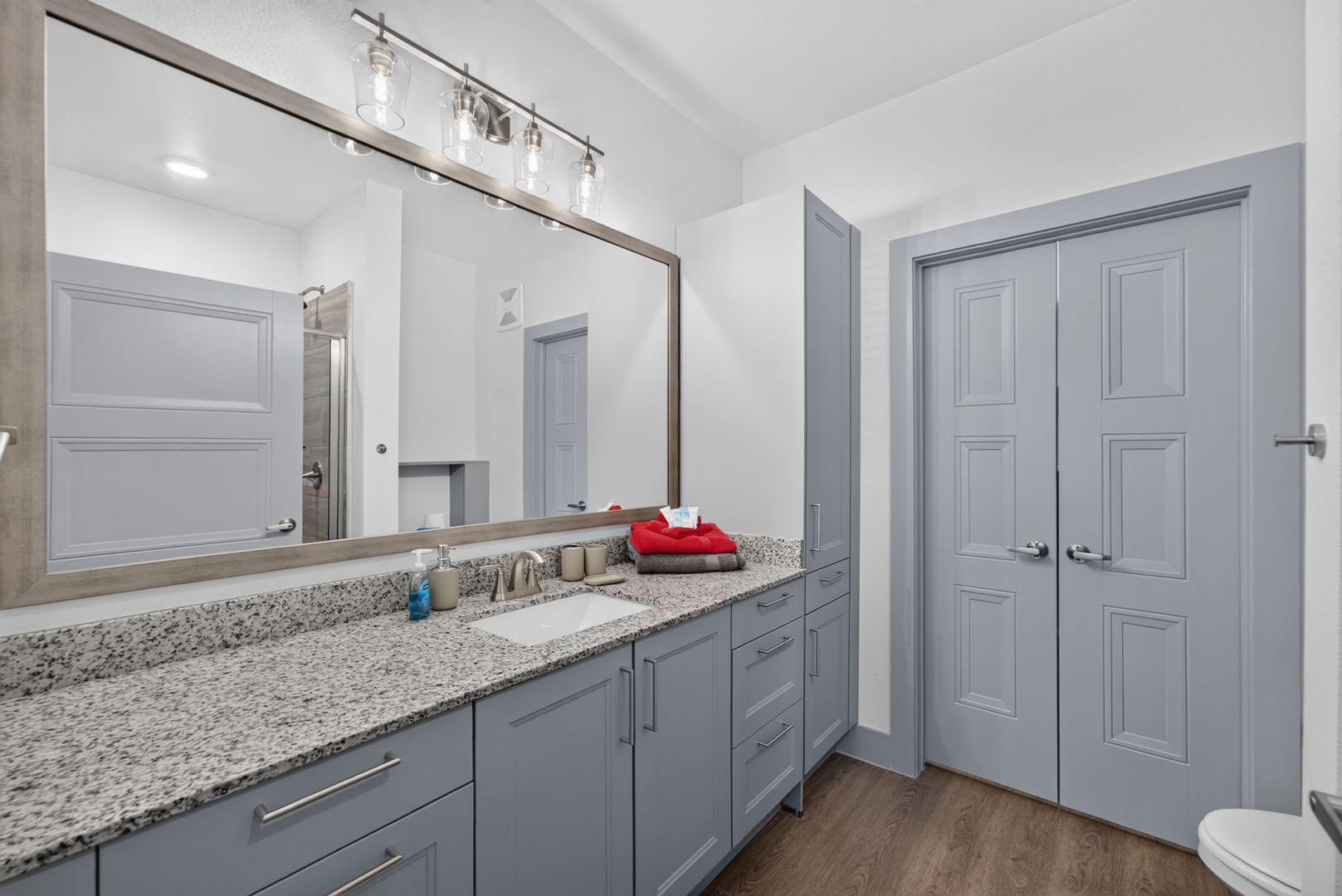 Freshen up in your modern bathroom, where sleek gray cabinetry and speckled granite countertops set the tone for a relaxing retreat. Plush towels await after your shower.