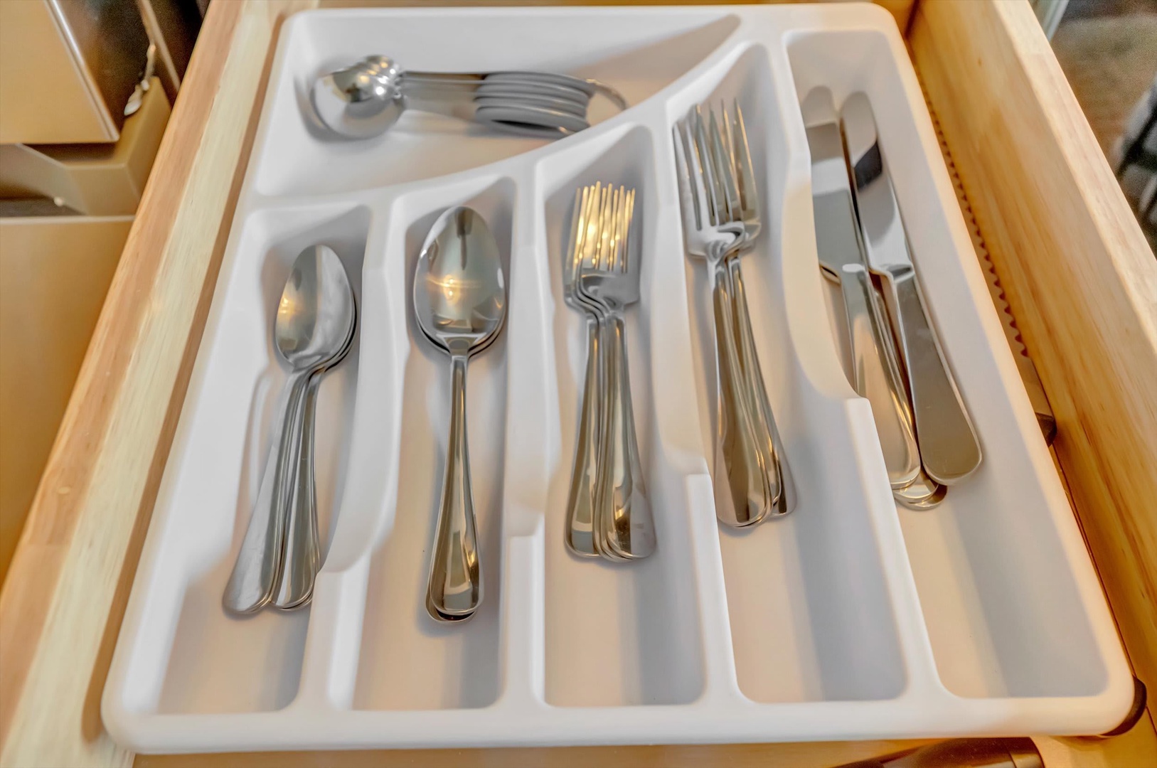 Your kitchen drawer is stocked with polished silverware, neatly organized and ready for every meal you'll enjoy here.