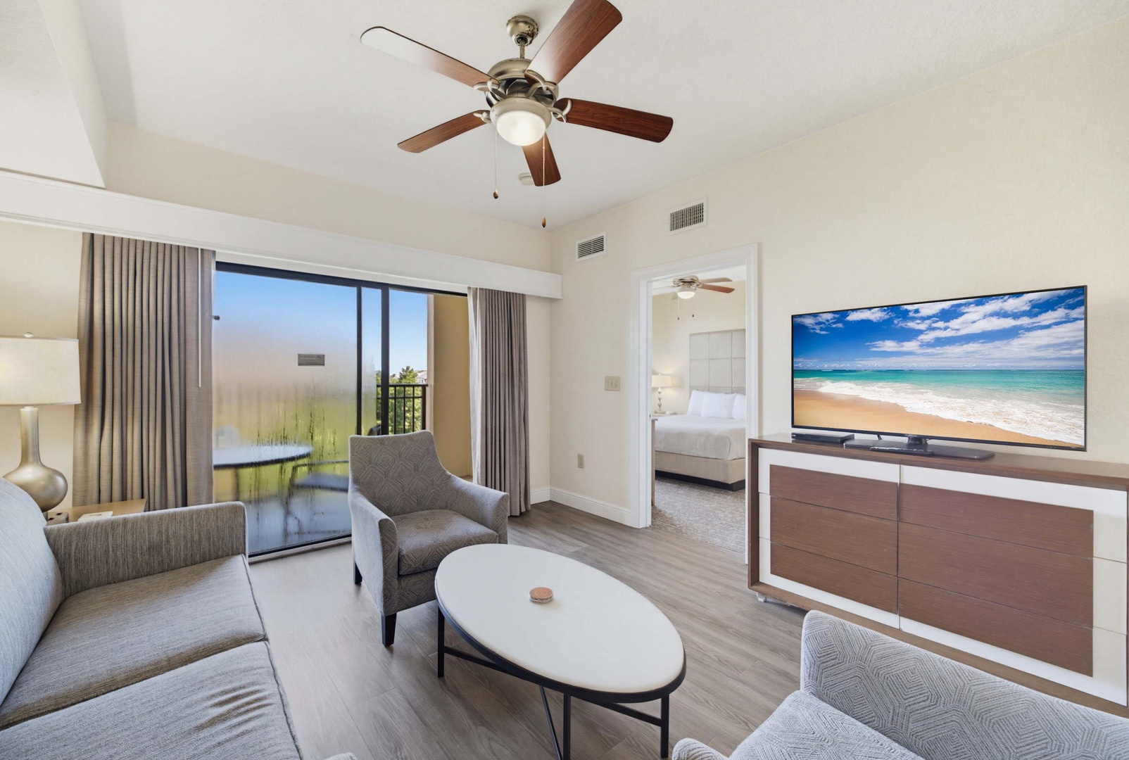 Step into your comfortable living space with vaulted ceilings, stylish furnishings, and sliding doors that frame the peaceful outdoor scenery, inviting you to unwind and feel right at home.