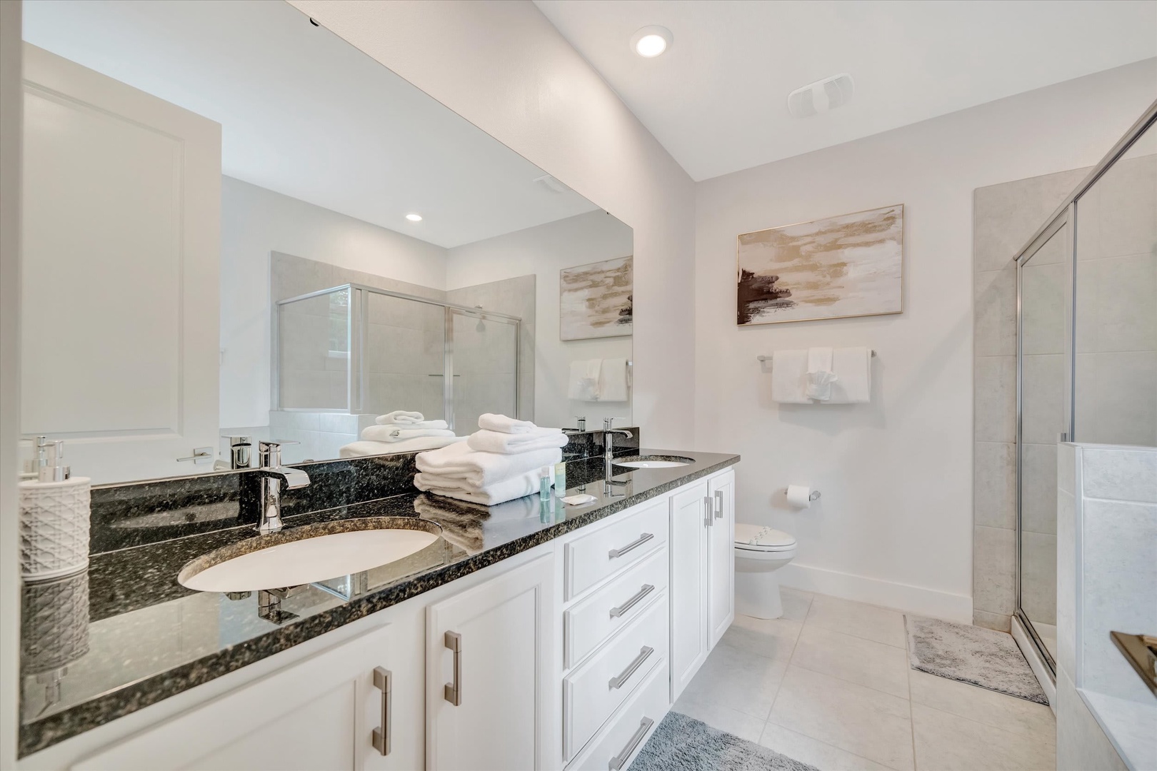 Refresh in your spacious, spa-inspired bathroom with sleek granite countertops, crisp white cabinetry, and plush towels ready for you. Step into the walk-in shower and let the day melt away.