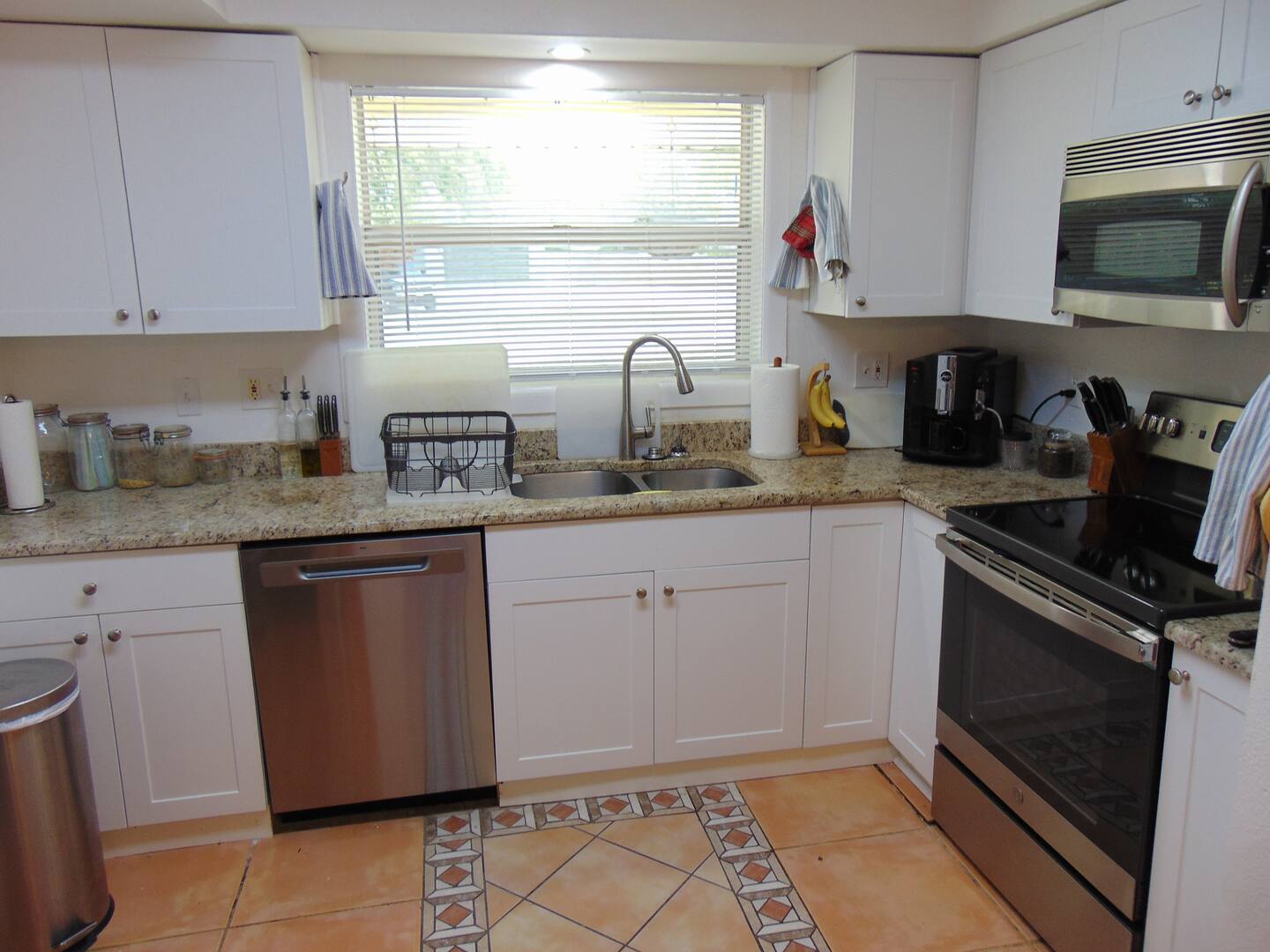 Your fully equipped kitchen invites you to whip up morning coffee or a home-cooked meal with ease, featuring modern appliances and a bright window view.