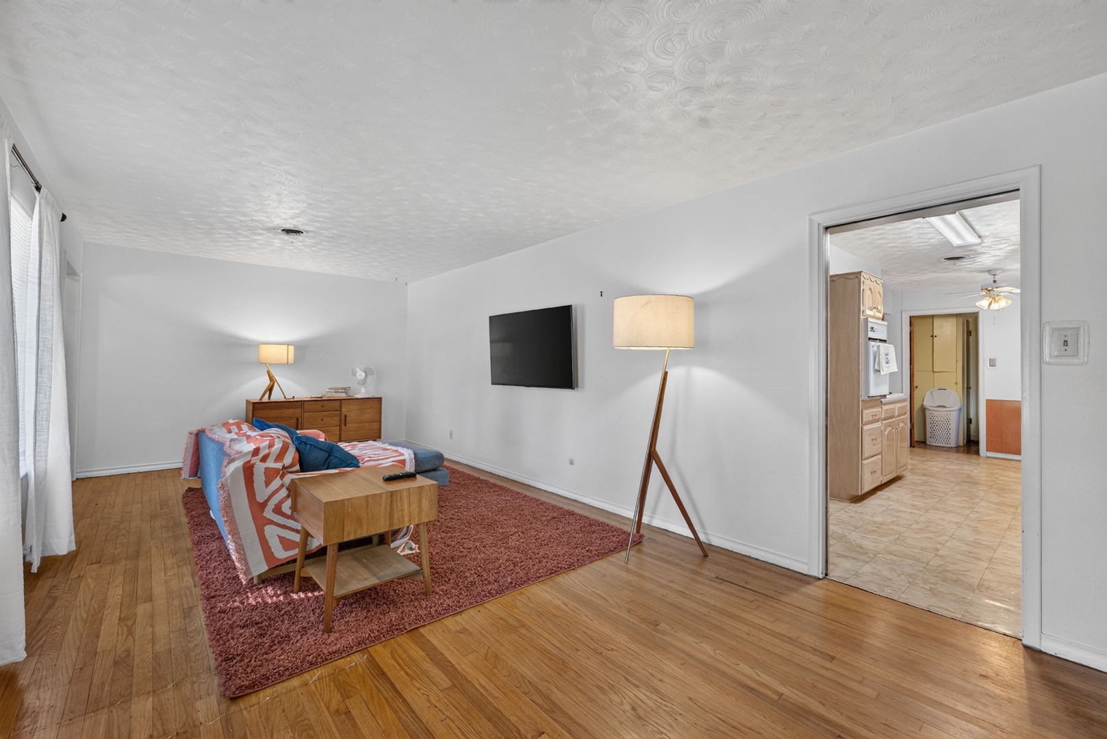 Step into your peaceful bedroom retreat with warm wood floors, mid-century furnishings, and a private en-suite just steps away—everything you need for a restful escape.