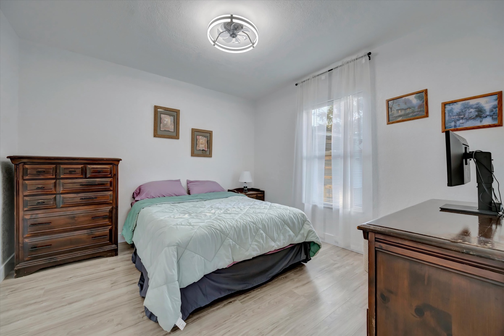 Sink into your cozy retreat after a day exploring. Light wood floors and a modern ceiling fan keep your room fresh and bright.
