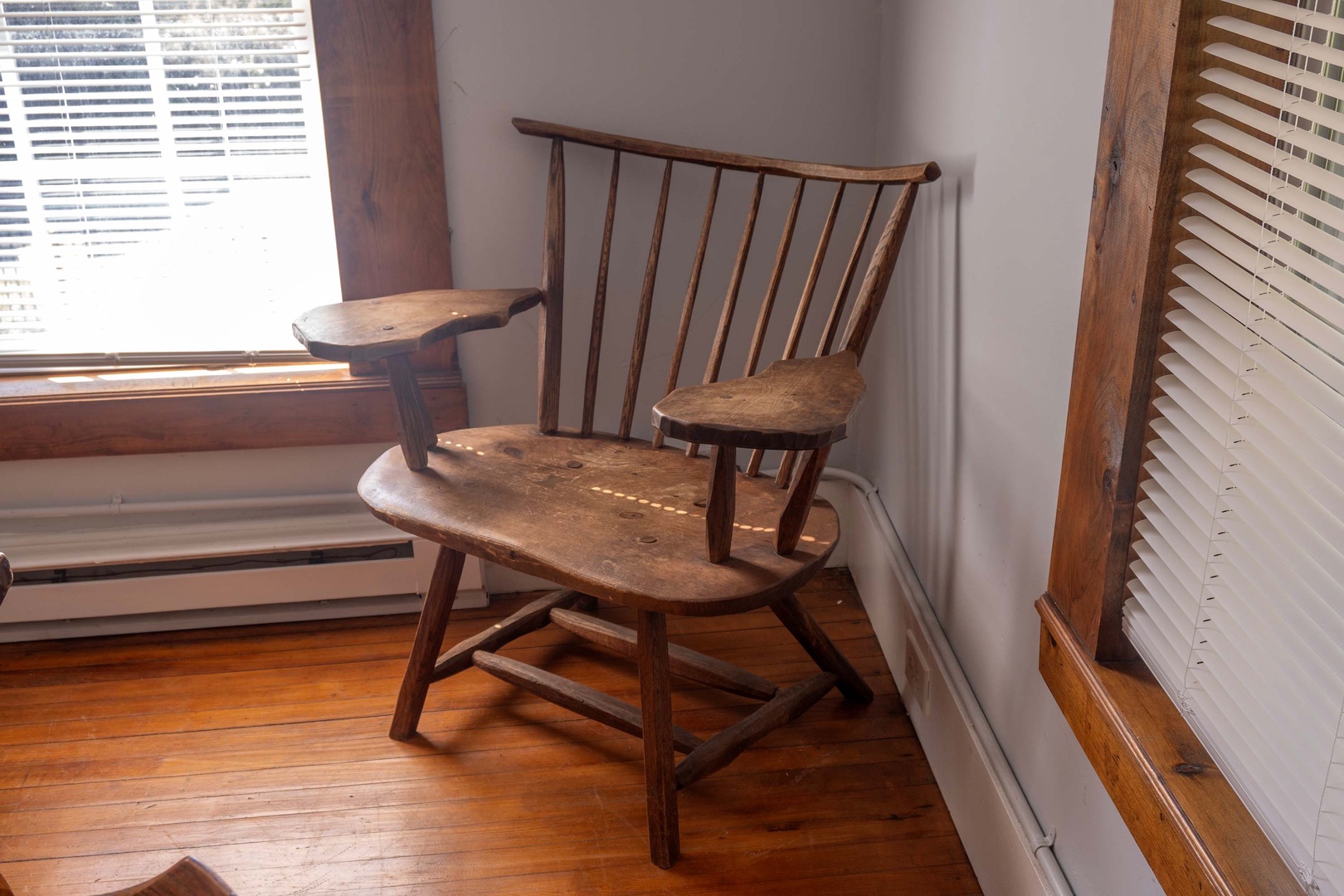 A charming antique wooden chair invites you to settle in by the sunny window with your morning coffee and a good book.