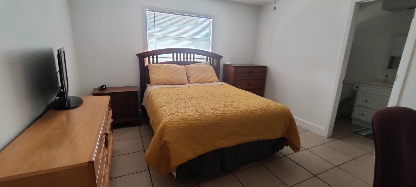 Step into your private retreat where warm golden tones create an inviting sanctuary. Your bedroom features tile flooring, comfortable furnishings, and a peaceful ambiance—perfect for unwinding after a day of adventure.