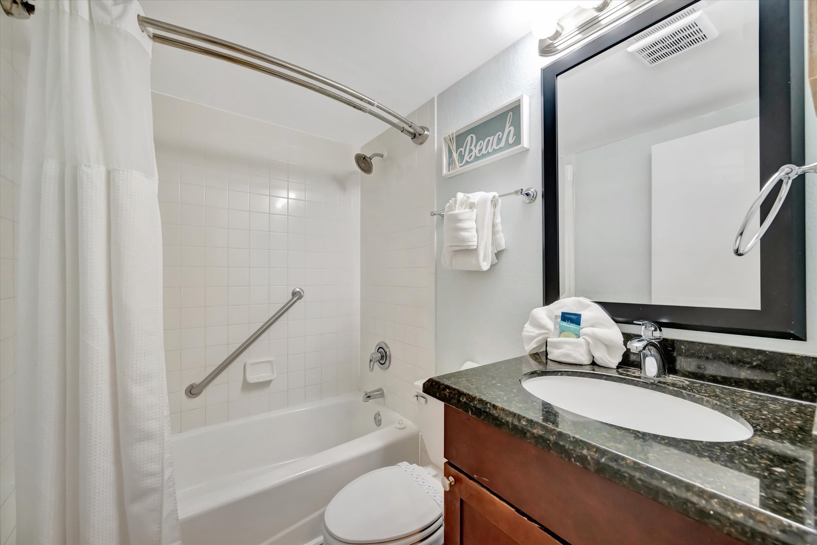 Step into your bright, clean bathroom with a fresh tub-shower combo and everything you need to feel at home. Plush towels, thoughtful amenities, and coastal touches welcome you after a day of exploring.