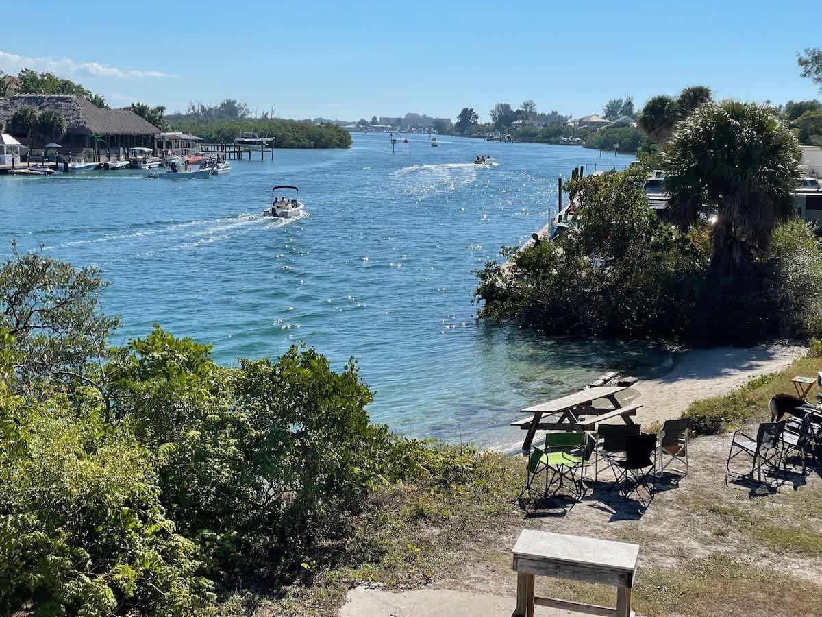 This waterfront property sits on a serene river where boats glide by and tropical greenery frames sparkling blue waters—your private escape with front-row seats to coastal beauty.