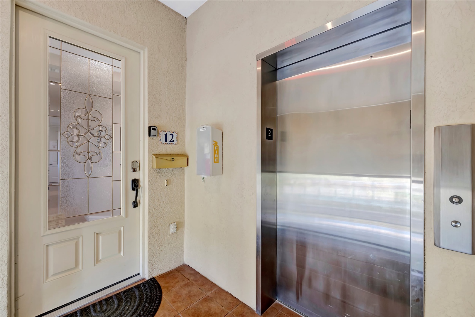 Private entrance hallway with convenient elevator access and decorative glass-panel door welcoming you to your rental space.