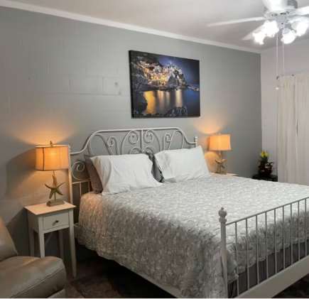 Step into your peaceful retreat with a cozy bed dressed in soft linens, gentle bedside lighting, and charming coastal accents that invite you to unwind and rest easy.