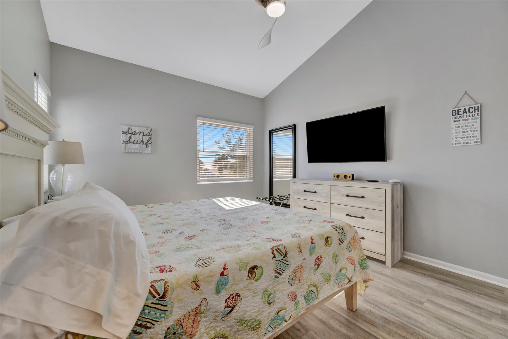 Sink into coastal comfort in your bright, airy bedroom featuring vaulted ceilings and soft natural light. The beachy decor and cheerful linens set a relaxing tone for your getaway.
