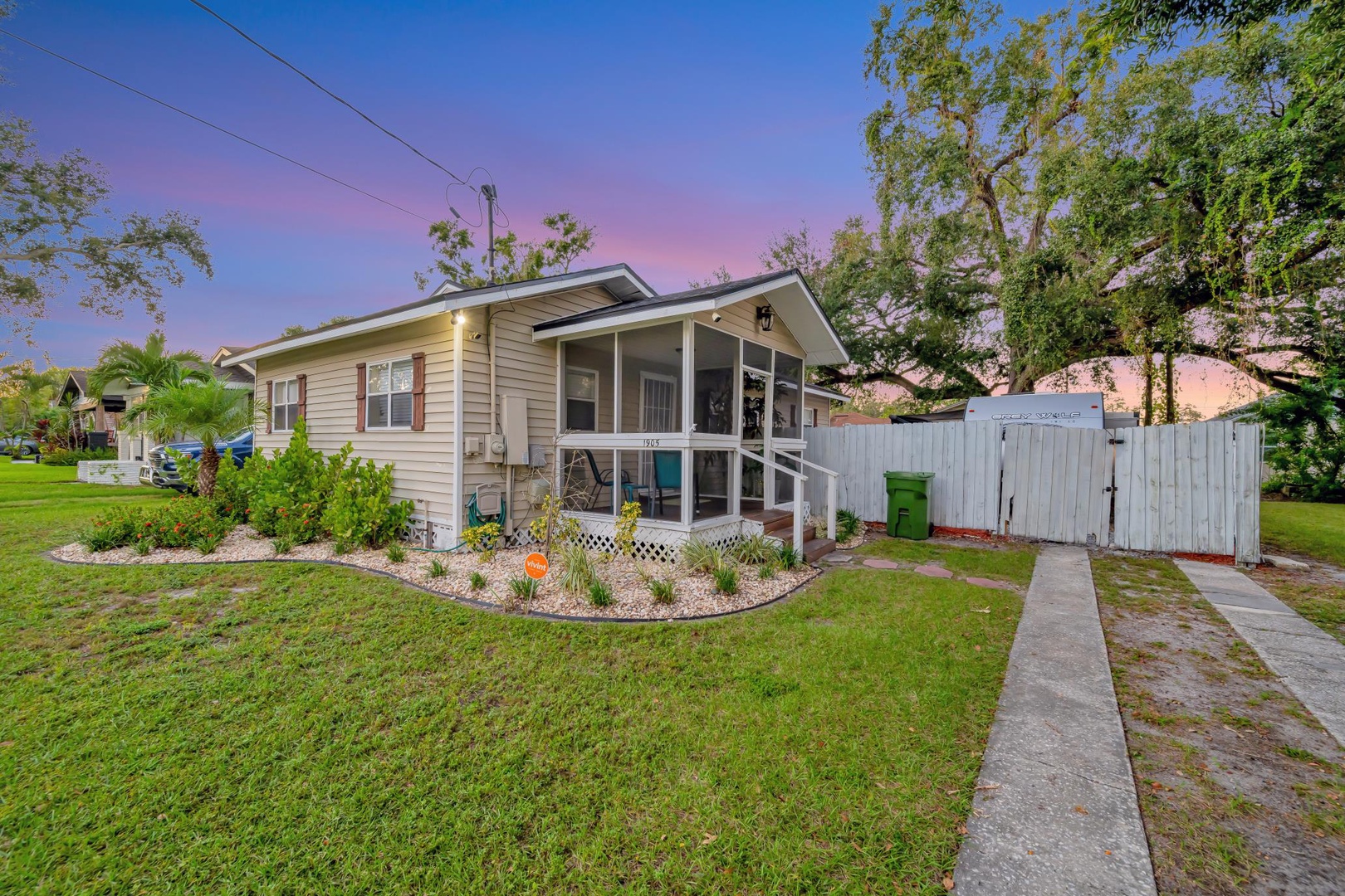 A charming property nestled in a peaceful neighborhood, surrounded by lush greenery and tropical palms, with ample outdoor space and a screened porch to enjoy the warm Florida evenings.