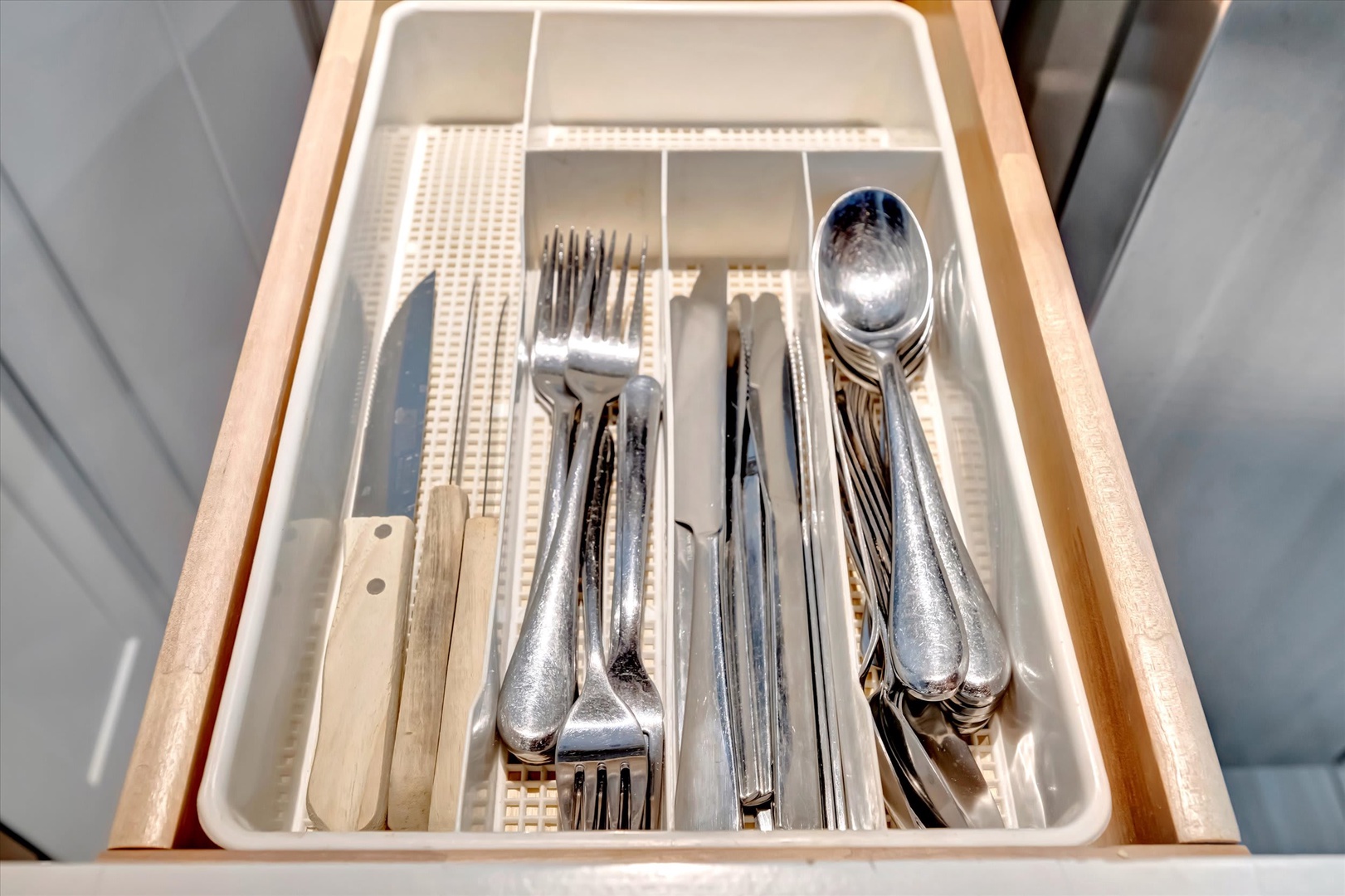 Your kitchen drawer is thoughtfully organized with quality utensils and cutlery, ready for your home-cooked meals.