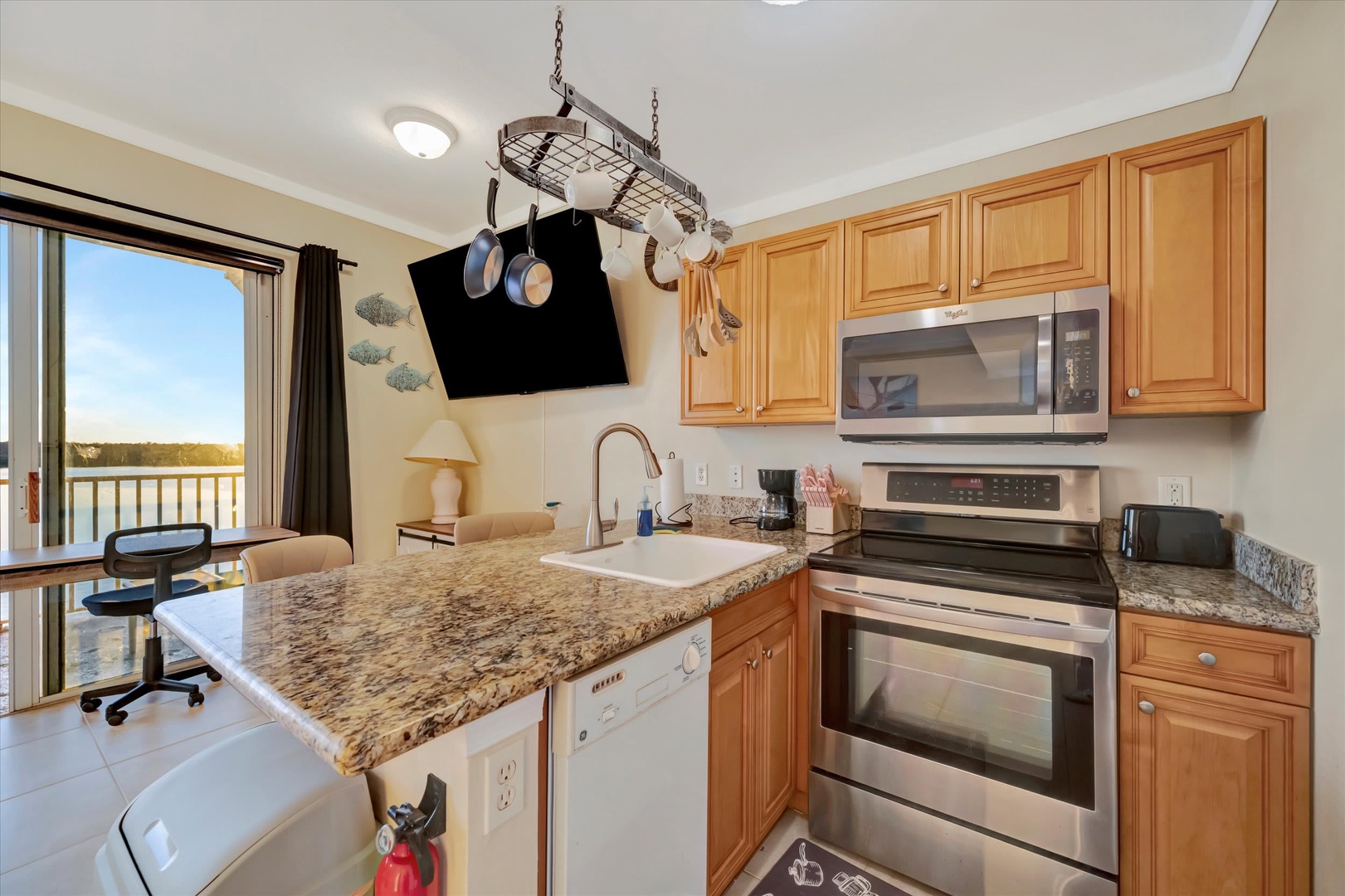 Your fully equipped kitchen makes meal prep a breeze, with granite counters, stainless appliances, and natural light streaming through the windows overlooking the water.
