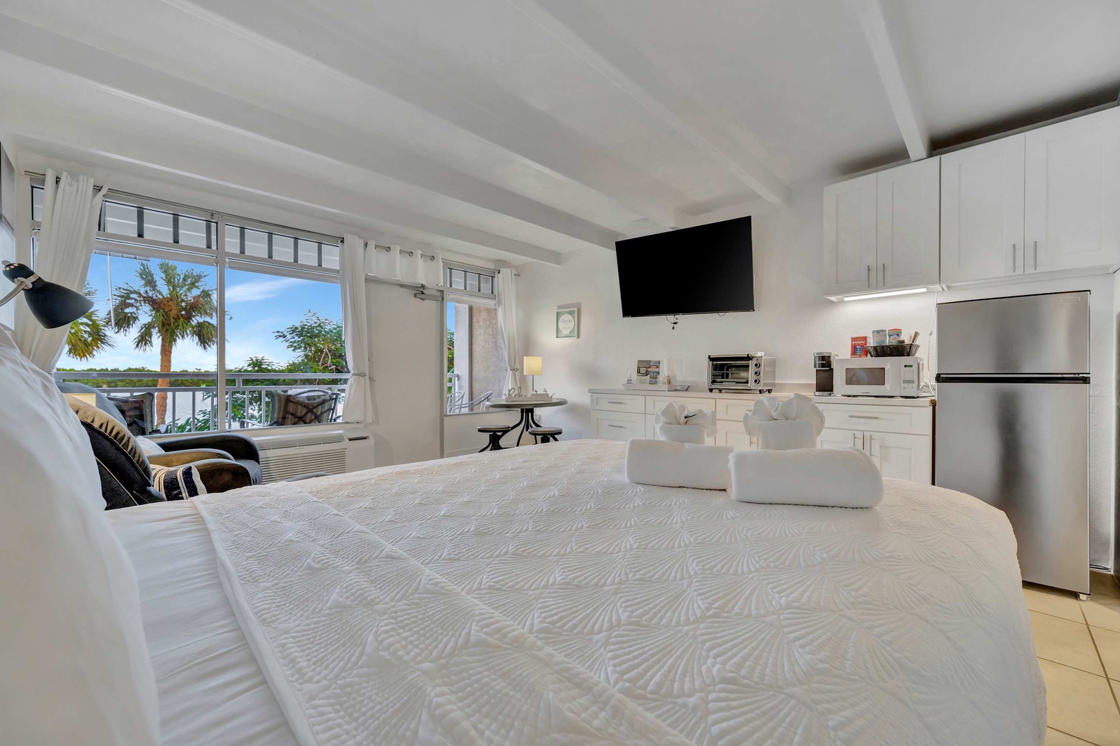 Relax in your bright studio where comfort meets convenience. Palm trees sway just beyond your window, while the fully equipped kitchenette makes it easy to settle in and feel at home.