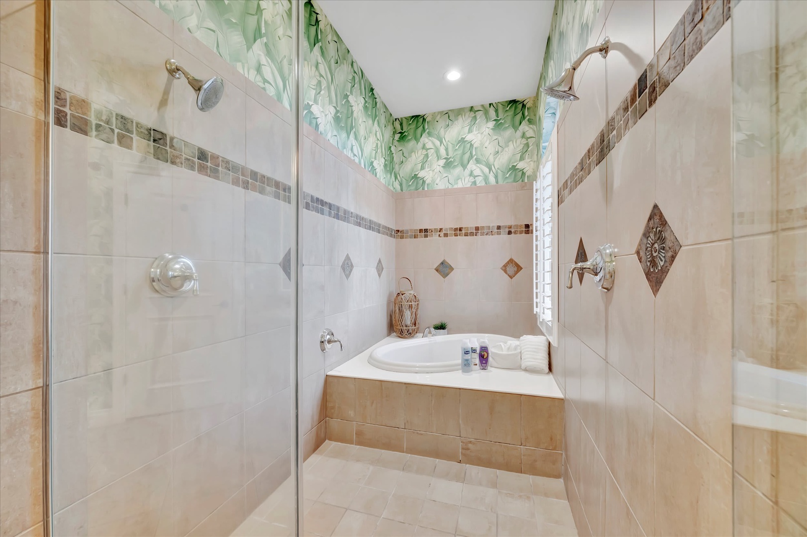Step into your spa-like sanctuary featuring a luxurious soaking tub and elegant walk-in shower with rainfall head. The tropical botanical wallpaper adds a refreshing touch to your private retreat.