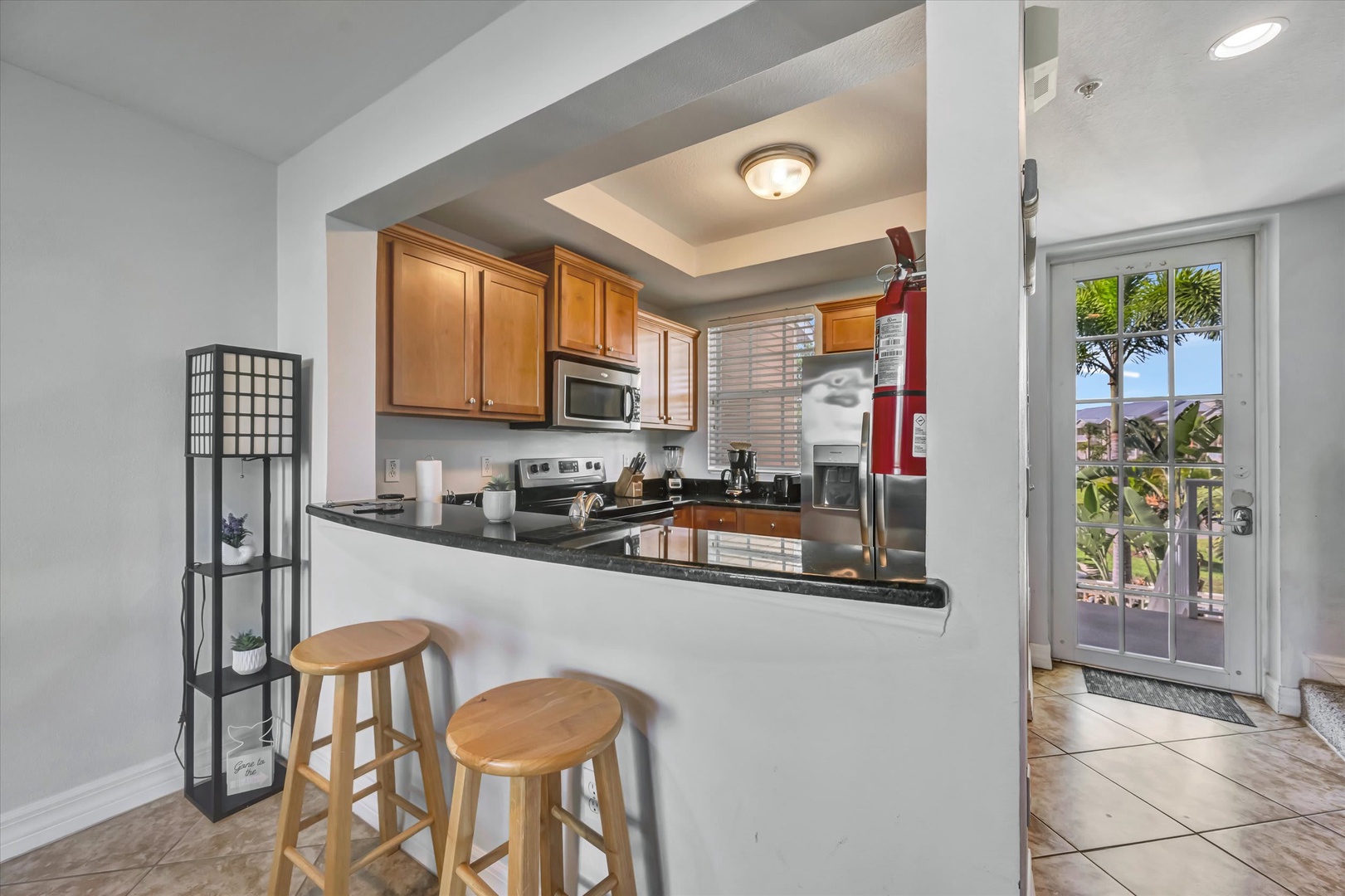 Step into your fully equipped kitchen with sleek countertops and modern appliances, where warm tropical breezes flow through open doors inviting you to paradise just beyond.
