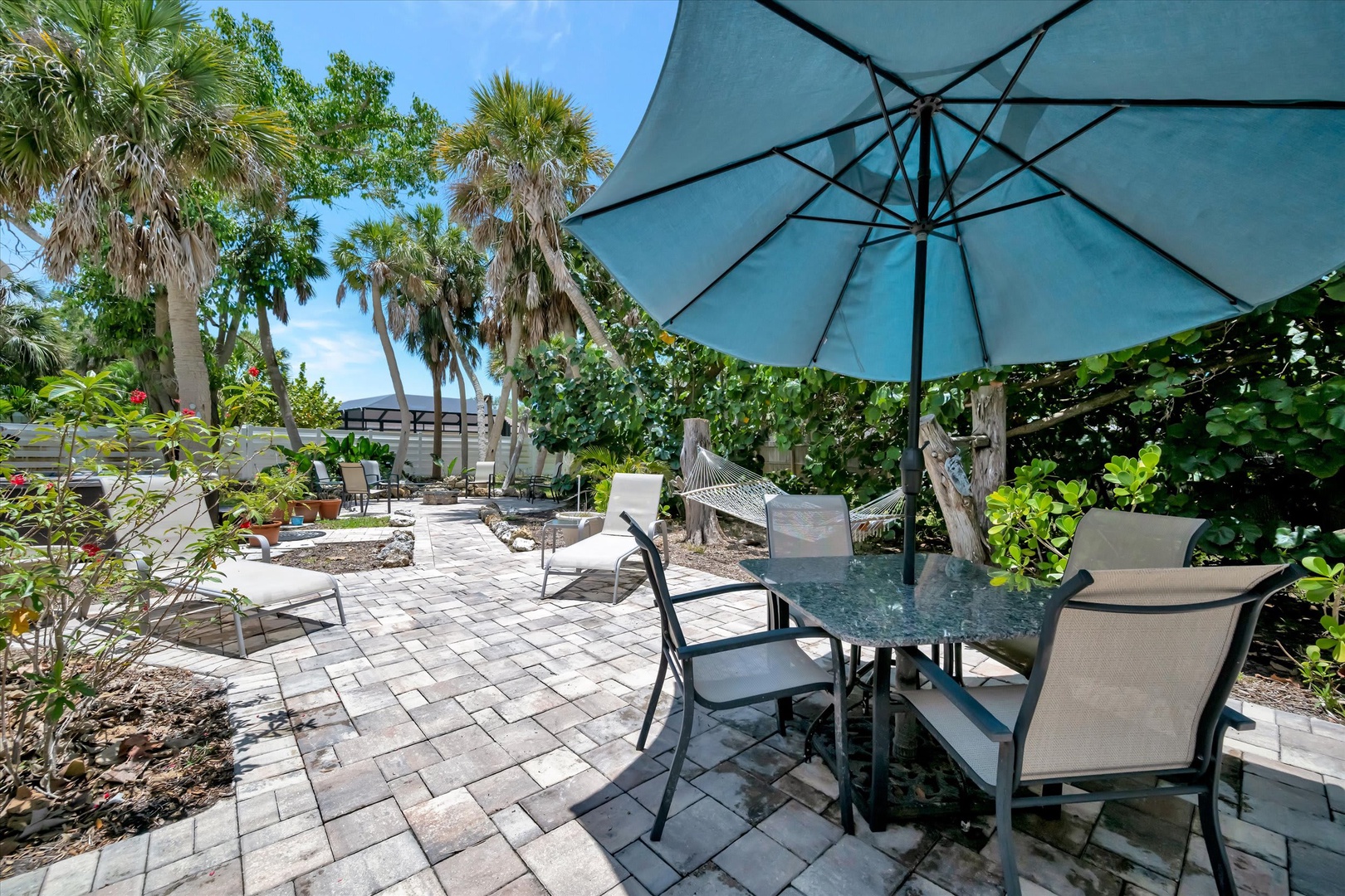 Step into your own tropical oasis where swaying palms and a hammock invite you to unwind. Dine alfresco under shade, then let the garden's natural beauty melt your worries away.