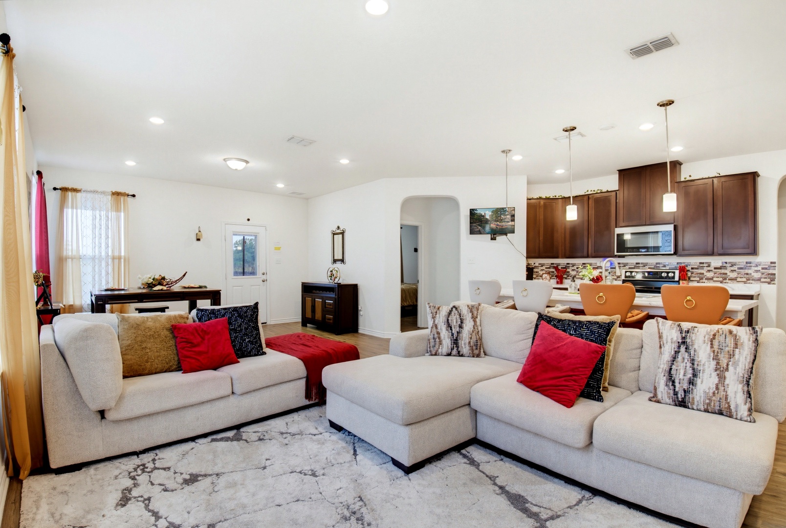 Sink into plush seating in your spacious, sunlit living area, where the open kitchen invites you to cook and connect. With colorful accents and modern comforts, this warm space is perfect for relaxing after your adventures.