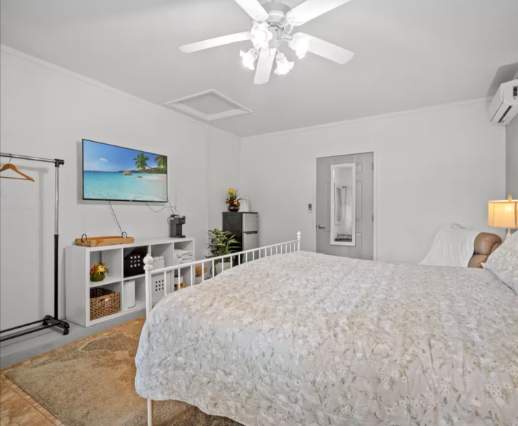 Step into your peaceful retreat with a plush bed, ceiling fan, and air conditioning for your comfort. Storage cubbies and cozy lighting make this space functional and welcoming for relaxation.
