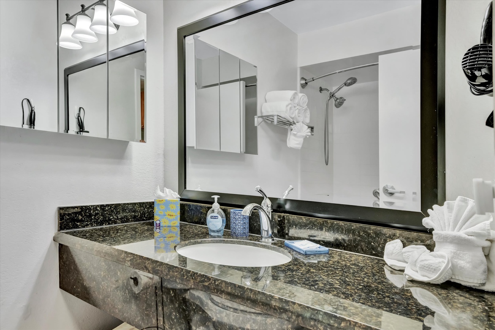 A modern bathroom with granite countertops, fresh towels, and a refreshing shower—your personal retreat after a day of exploring.