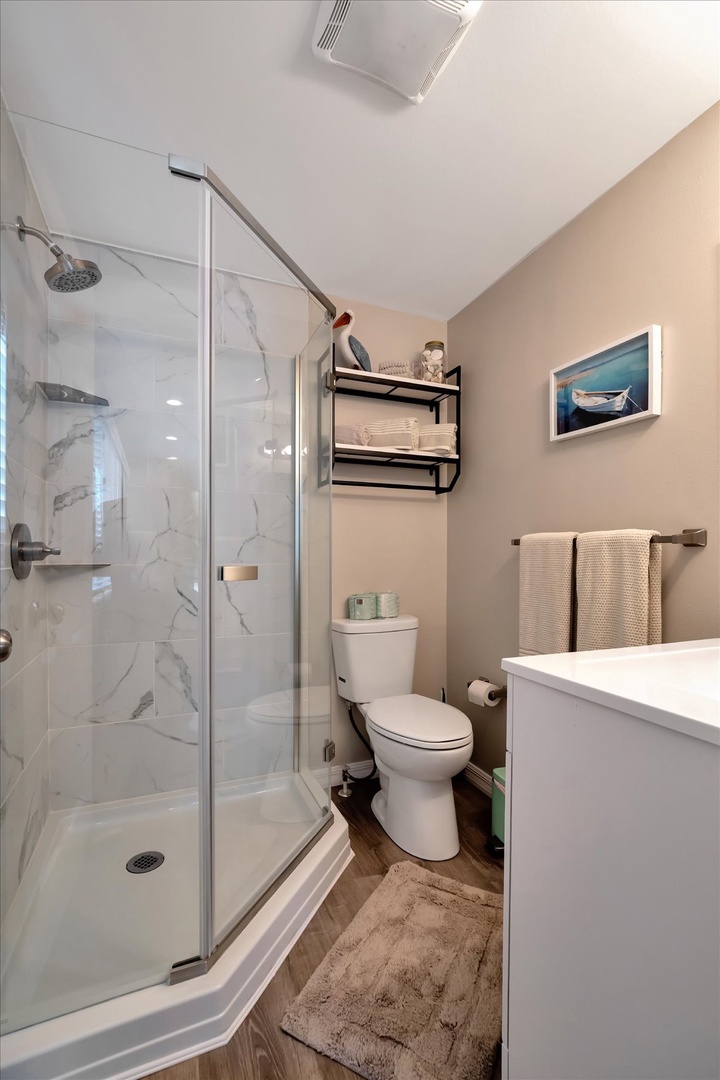 Your private bathroom offers a sleek walk-in shower, fresh towels, and modern fixtures to refresh after a day of exploring.