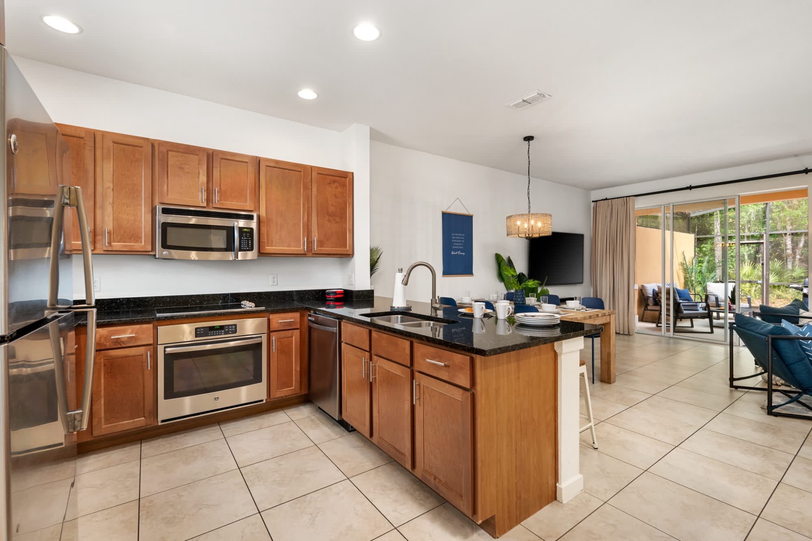 Open-concept retreat with sleek granite countertops, stainless steel appliances, and warm wood cabinetry. Glass doors open to a private patio perfect for gathering and soaking in the sunshine.