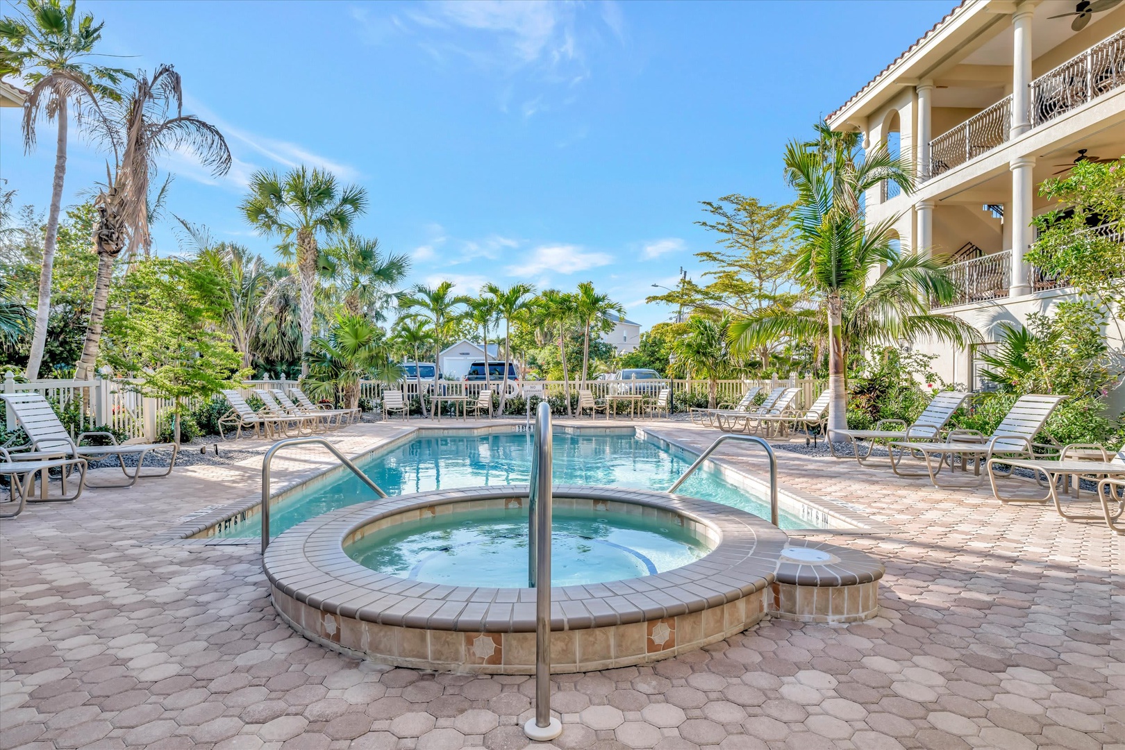 This tropical poolside oasis features a sparkling hot tub and inviting swimming pool, surrounded by swaying palms and plenty of lounge chairs for soaking up the Florida sunshine.