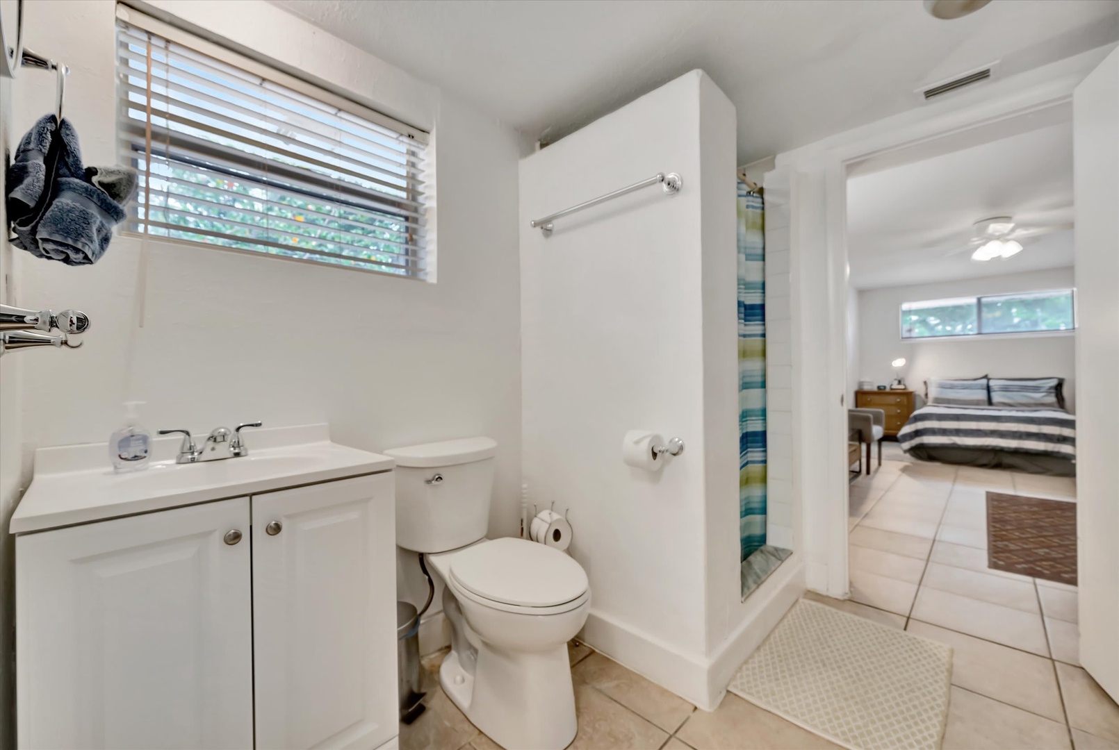Your private en-suite bathroom features crisp white finishes and a refreshing shower, conveniently connecting to your cozy bedroom for easy access and comfort.
