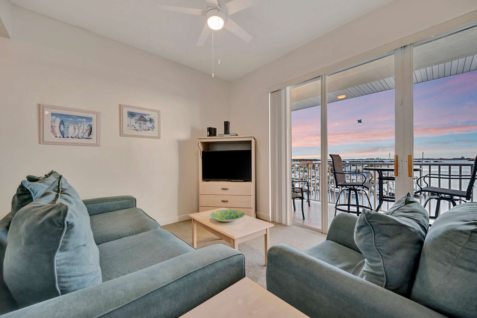 Unwind in this inviting living space where comfort meets coastal charm. Sink into plush seating and step out to your private balcony to catch stunning waterfront sunsets painting the sky each evening.