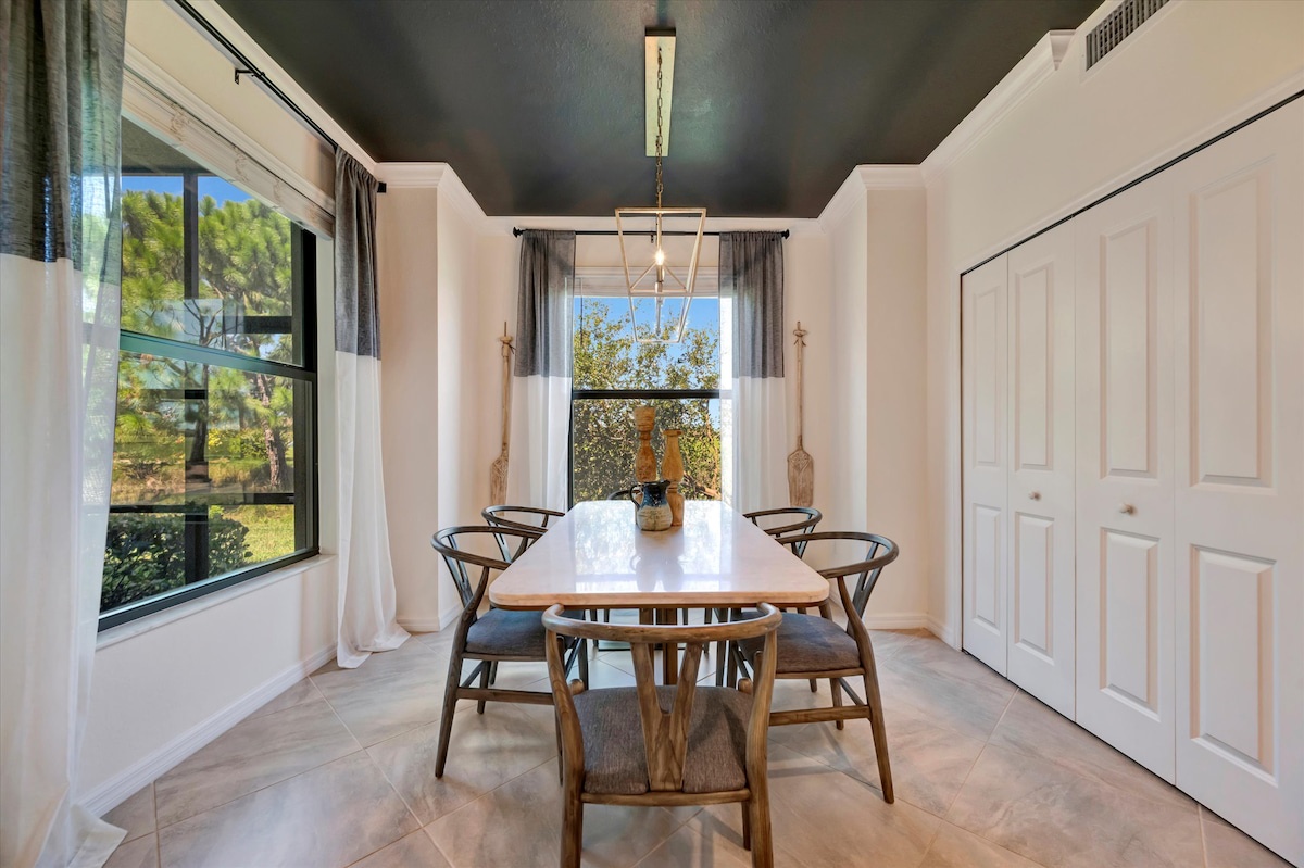 Striking dining space with bold design, natural light, and sleek modern furnishings. Dark ceilings and warm wood accents create a sophisticated atmosphere for memorable meals.
