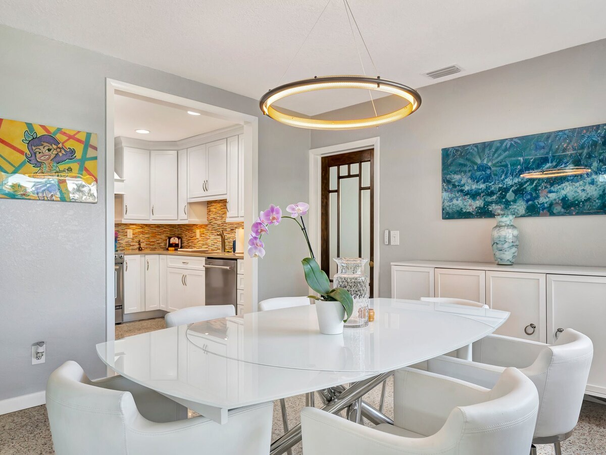 Gather around the elegant dining table where sleek modern design meets comfort. The open layout flows seamlessly into your fully equipped kitchen, perfect for relaxed meals and lively conversation.