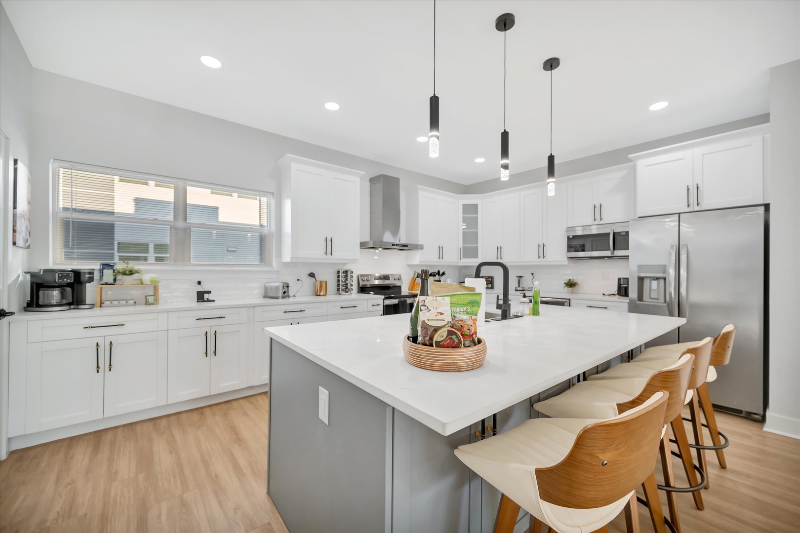Picture yourself preparing meals in this bright, modern kitchen with sleek white cabinetry, stainless steel appliances, and a spacious island where you can gather with loved ones for morning coffee or evening conversation.