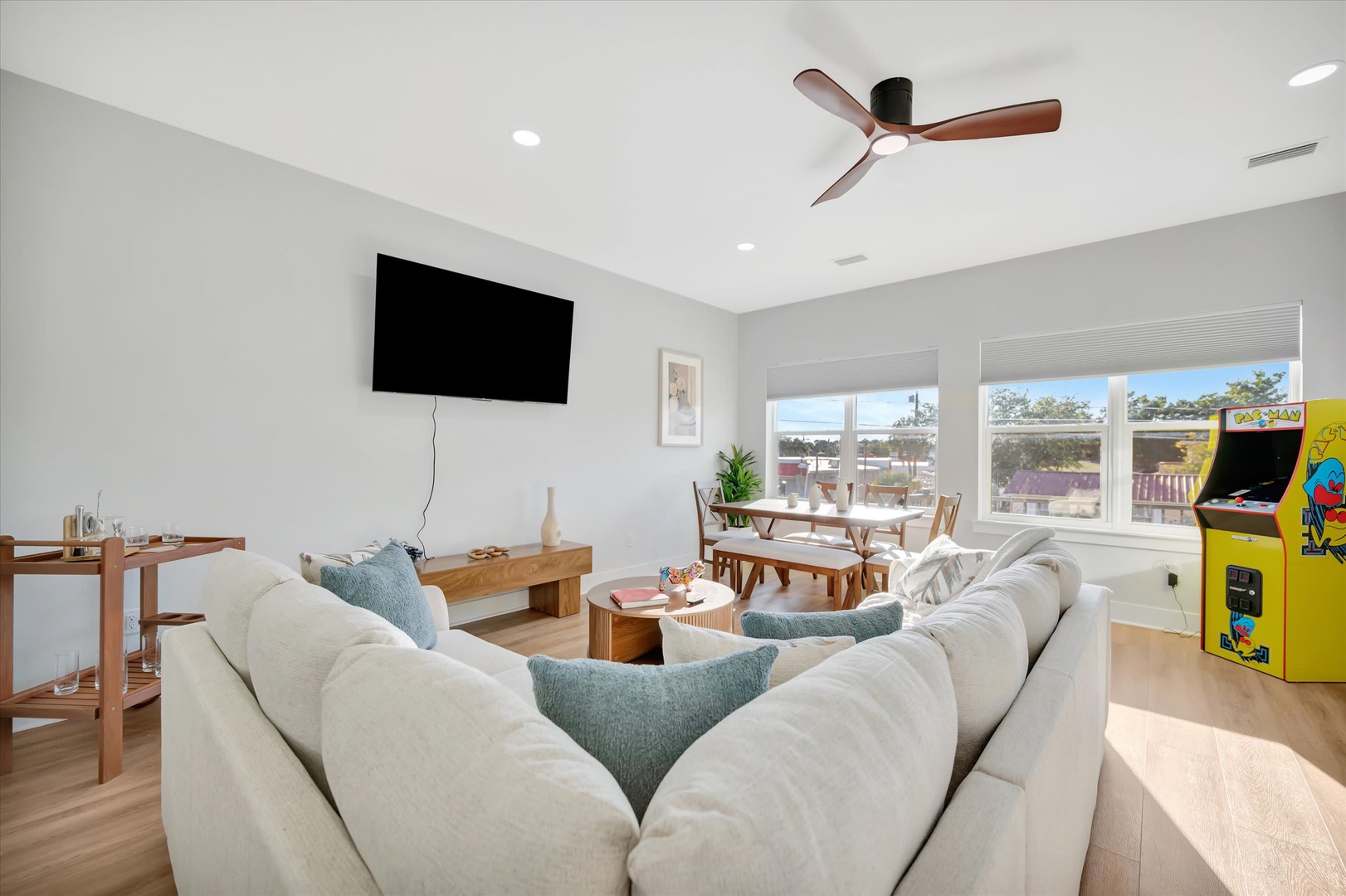 Relax in your bright, open living space with plush seating and classic arcade fun. Natural light pours through large windows, while the sleek ceiling fan keeps you comfortable as you unwind or challenge friends to a game.