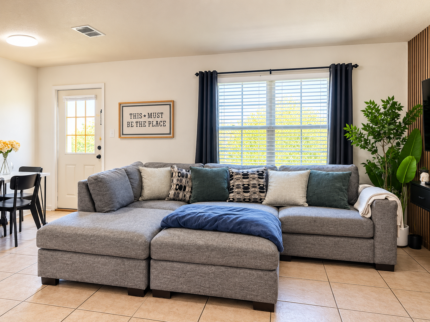 Sink into the plush sectional and feel instantly at home. Natural light floods your living space, while lush greenery and thoughtful décor create a peaceful, welcoming atmosphere for your stay.