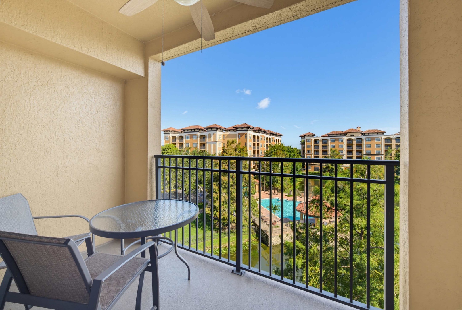 Step onto your private balcony and take in the sparkling pool below, surrounded by lush tropical landscaping and clear blue skies.