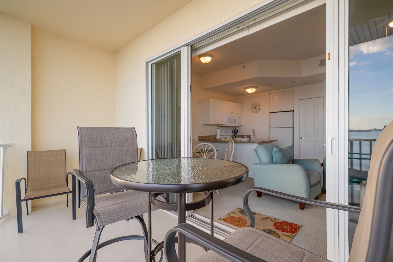 Step onto your private balcony and savor morning coffee at the outdoor table while enjoying peaceful views of the surrounding area and glimpses of water beyond.