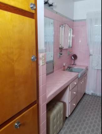 Step into your retro-chic bathroom with vintage pink tile and plenty of counter space for all your essentials.