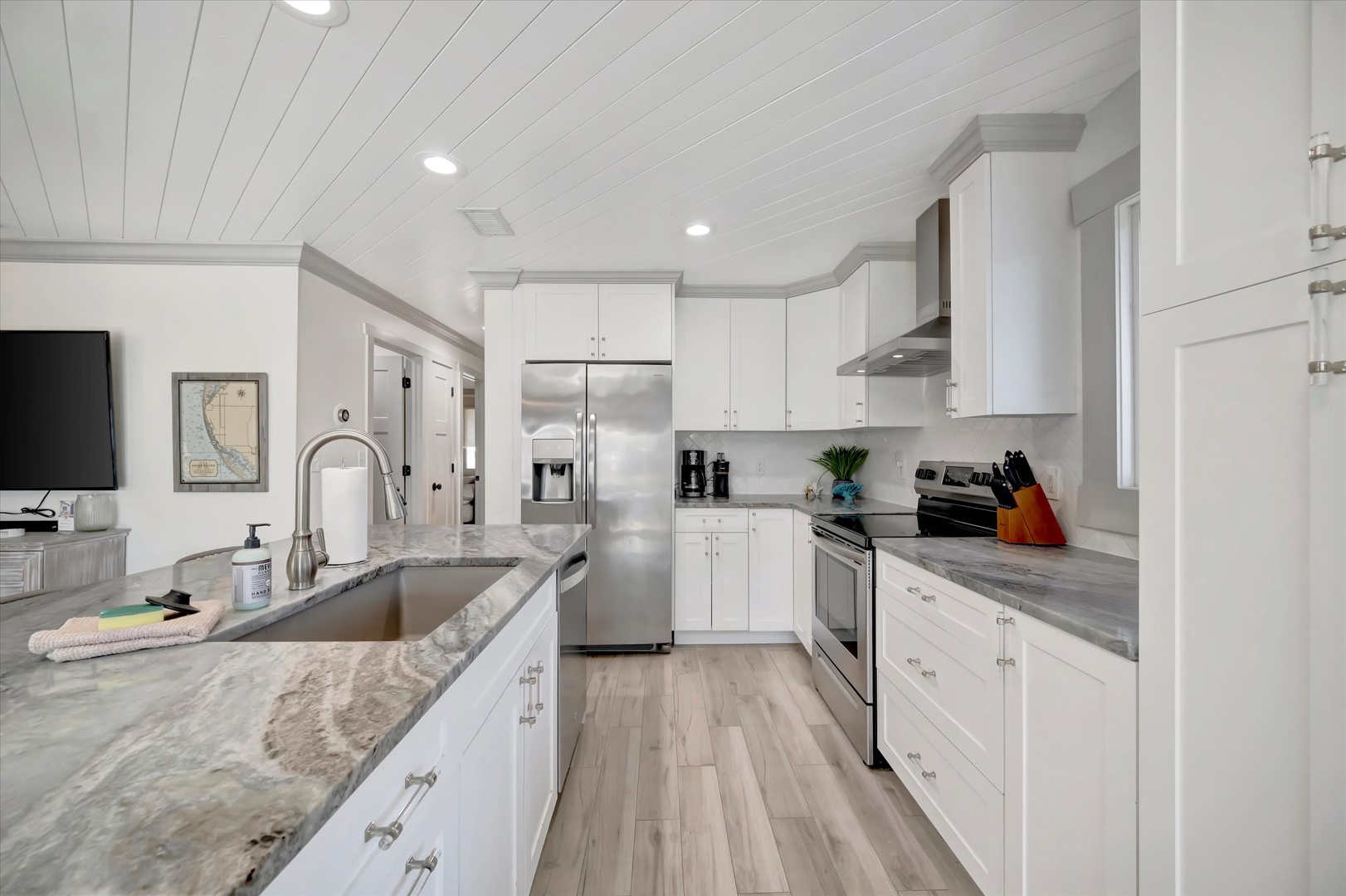 Your chef's kitchen awaits with gleaming white cabinetry, premium stainless appliances, and plenty of counter space to prep your favorite meals in comfort and style.