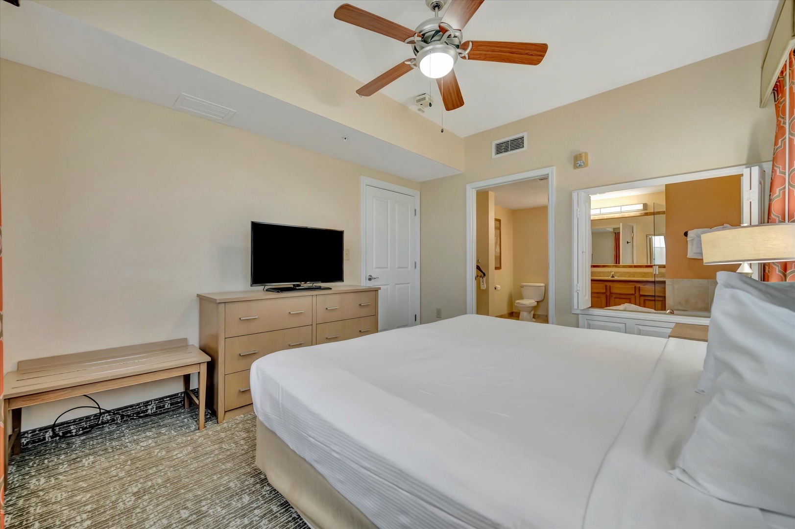 Sink into your crisp white bed after a day of exploring. Your private ensuite bath awaits just steps away, and a ceiling fan keeps the air fresh and cool.