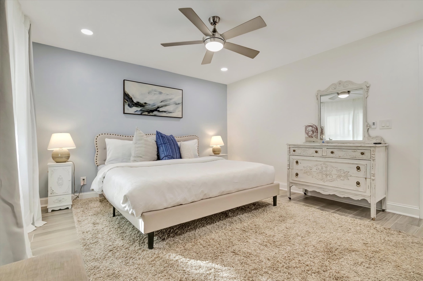 Settle into your serene bedroom retreat, where plush bedding and soft lighting invite you to unwind. The elegant furnishings and calming coastal palette create the perfect space for restful nights and relaxed mornings.