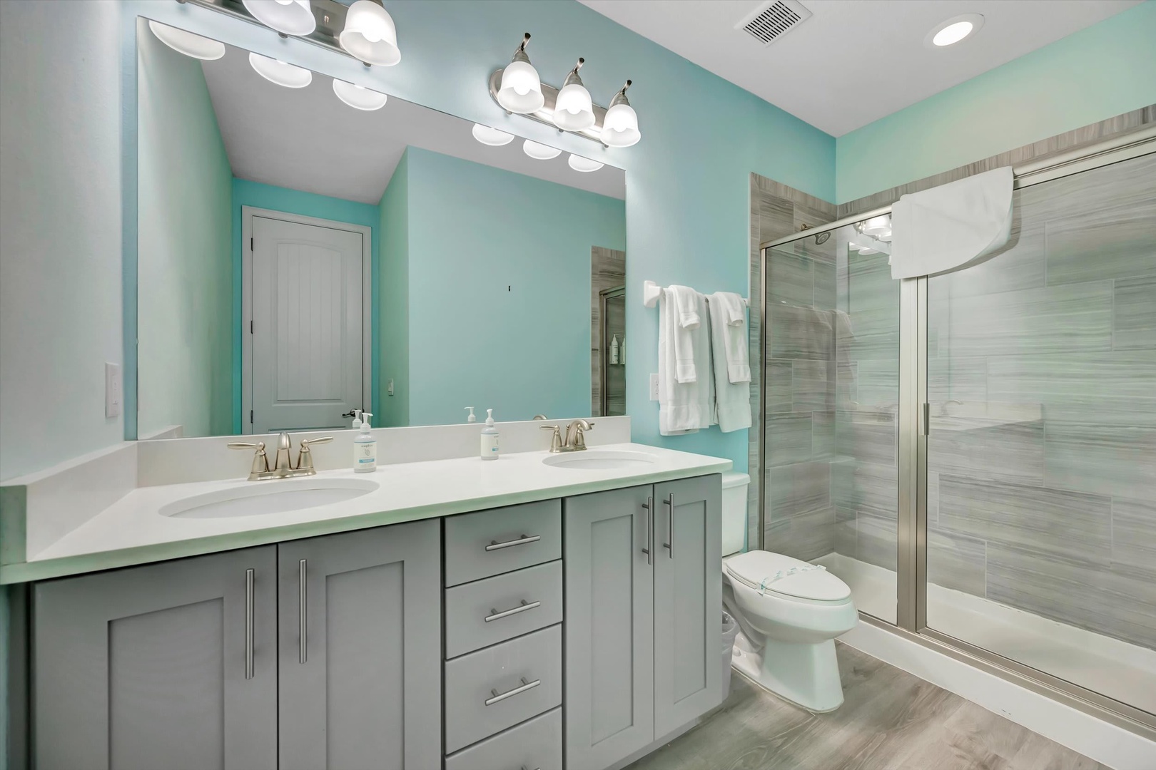 Step into your own coastal-inspired retreat with soft aqua walls, a sleek double vanity, and a spacious walk-in shower designed for ultimate relaxation and ease.