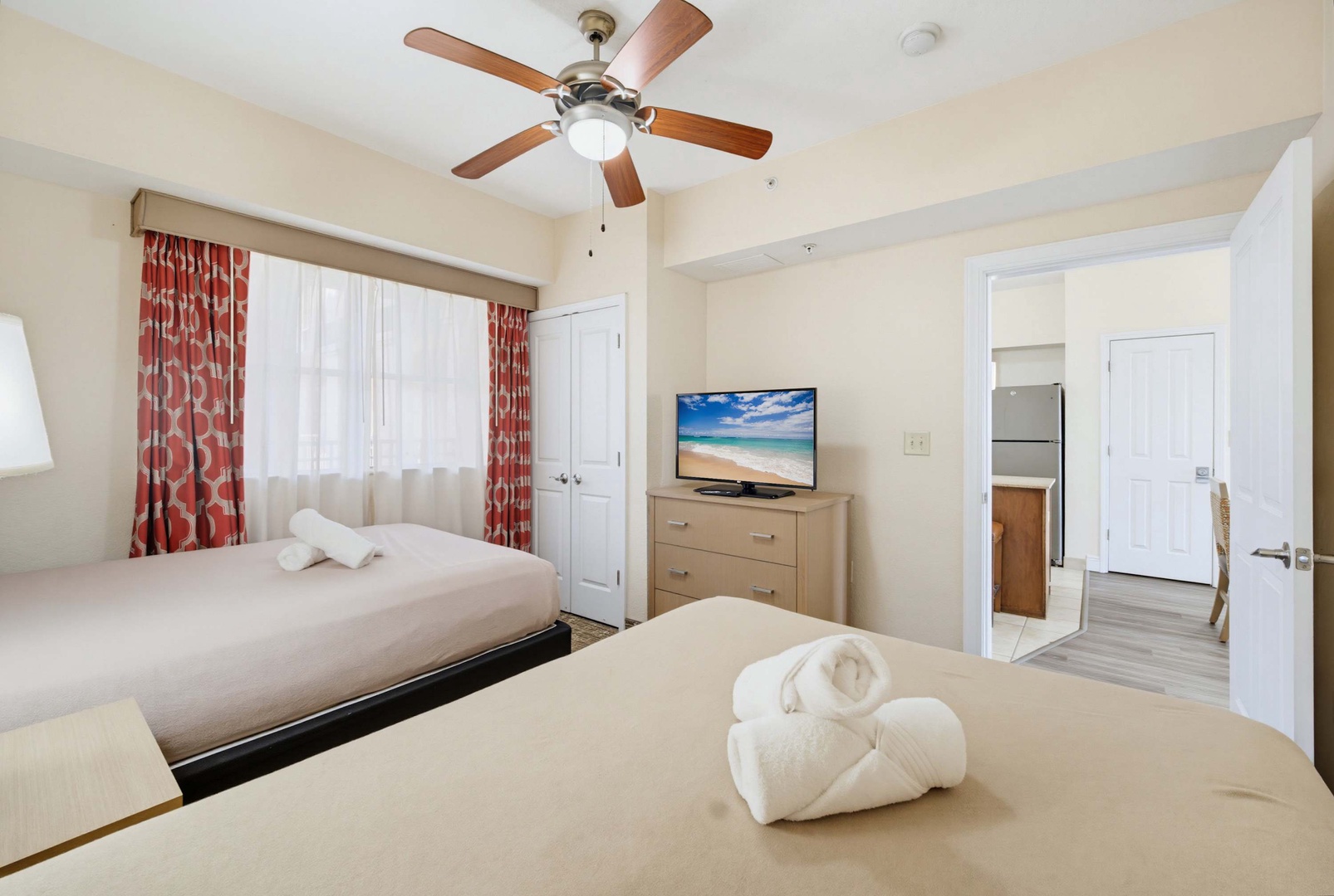 Unwind in your cozy bedroom with two comfortable beds, fresh linens waiting for you, and a gentle ceiling fan to keep you cool. Natural light streams through sheer curtains while your private en-suite awaits just steps away.