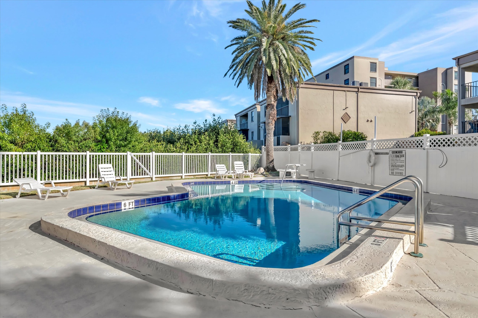 Dive into refreshment in your inviting pool, surrounded by swaying palms and sunny skies—perfect for soaking up warm coastal days.