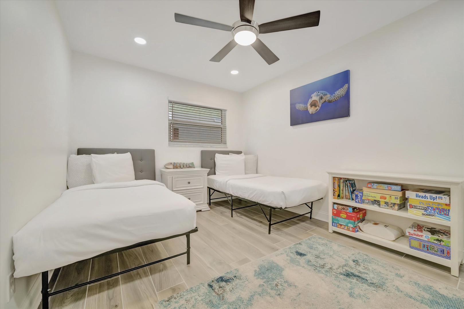 Your kids will love this bright bedroom with twin beds, a ceiling fan to keep cool, and a fun collection of games and books to enjoy together during downtime.