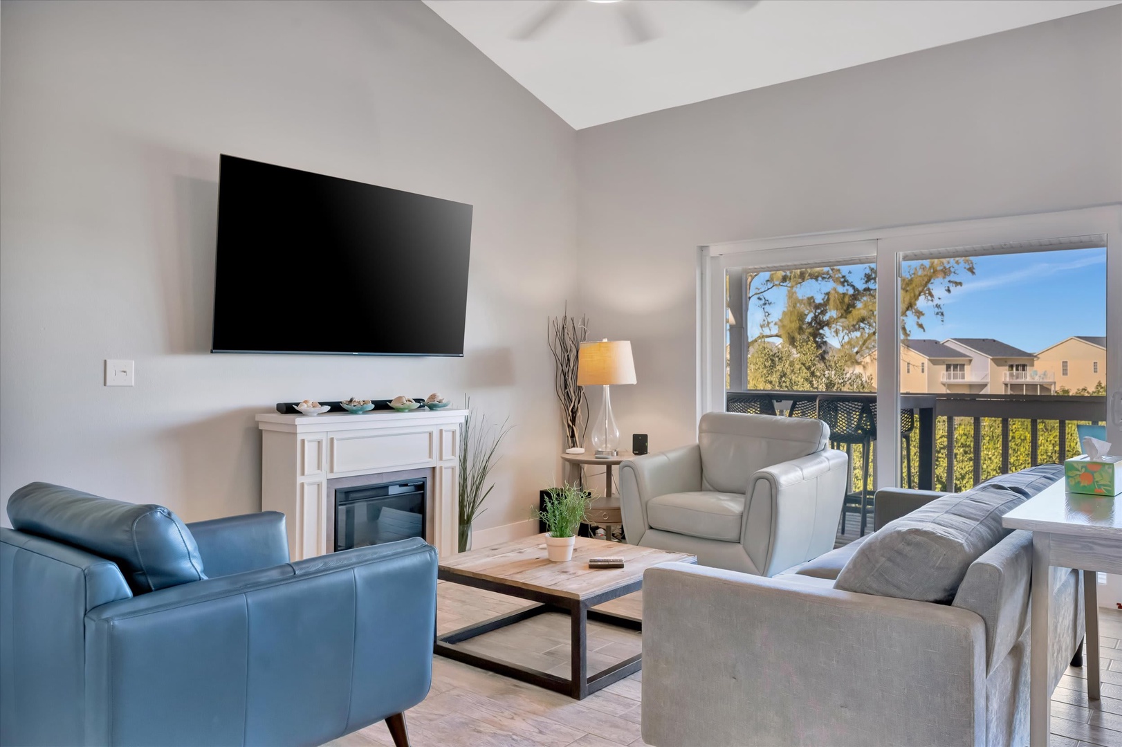 Your spacious living room invites relaxation with comfortable seating, natural light streaming through glass doors, and a cozy electric fireplace—perfect for unwinding after a day of exploring.