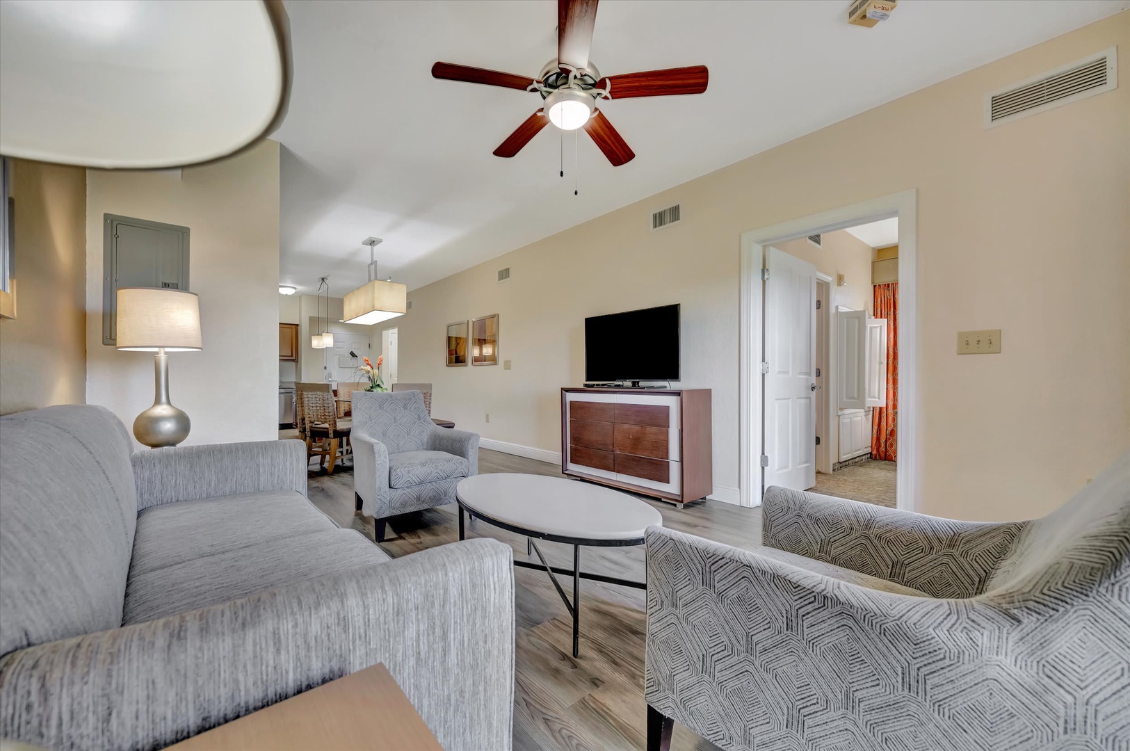 Relax in your open living area with plush seating and modern touches. A ceiling fan keeps you cool, and the TV invites cozy movie nights after a day exploring.